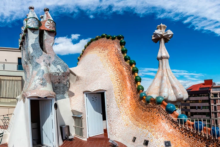 découvrez le toit emblématique de la casa batlló, une œuvre maîtresse de l'architecture moderniste conçue par antoni gaudí. plongez dans l'univers féérique de ses formes organiques et de ses mosaïques colorées qui font de cet édifice un incontournable de barcelone.